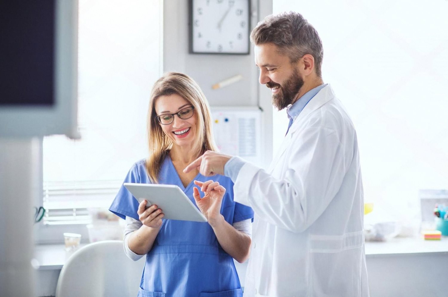 Doctor and nurse reviewing a patient's proctology report on a tablet in a Dubai clinic
