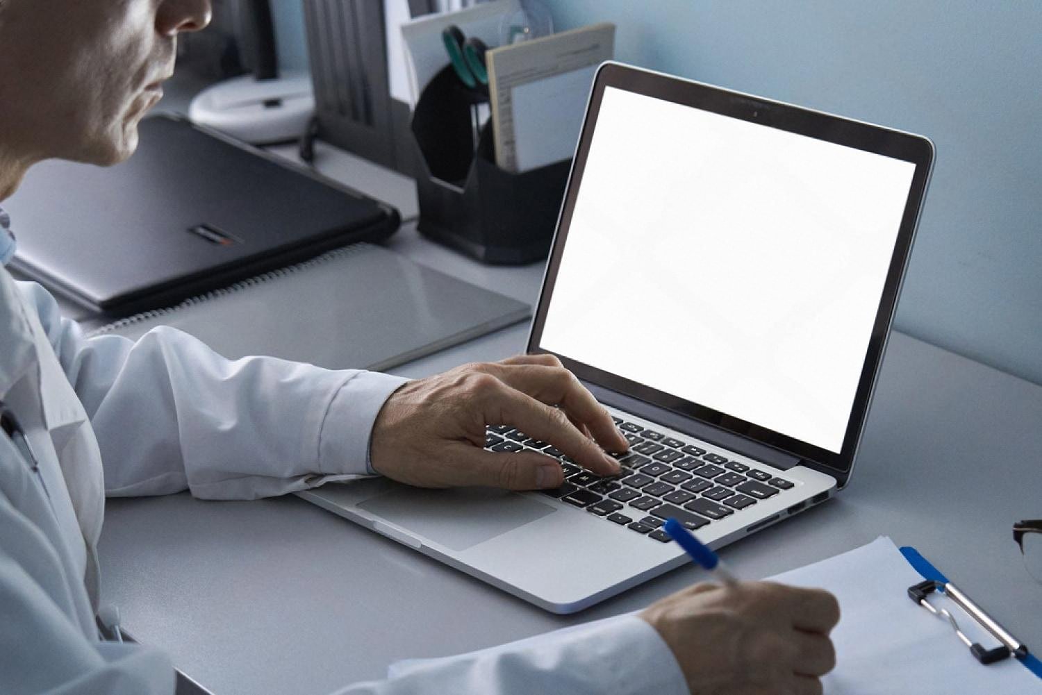 Doctor entering patient appointment details on a laptop at a UAE clinic